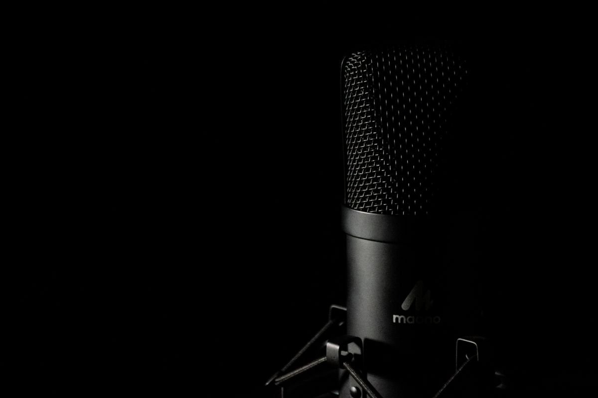 Detailed close-up of a studio microphone with a dark background, ideal for audio production themes.